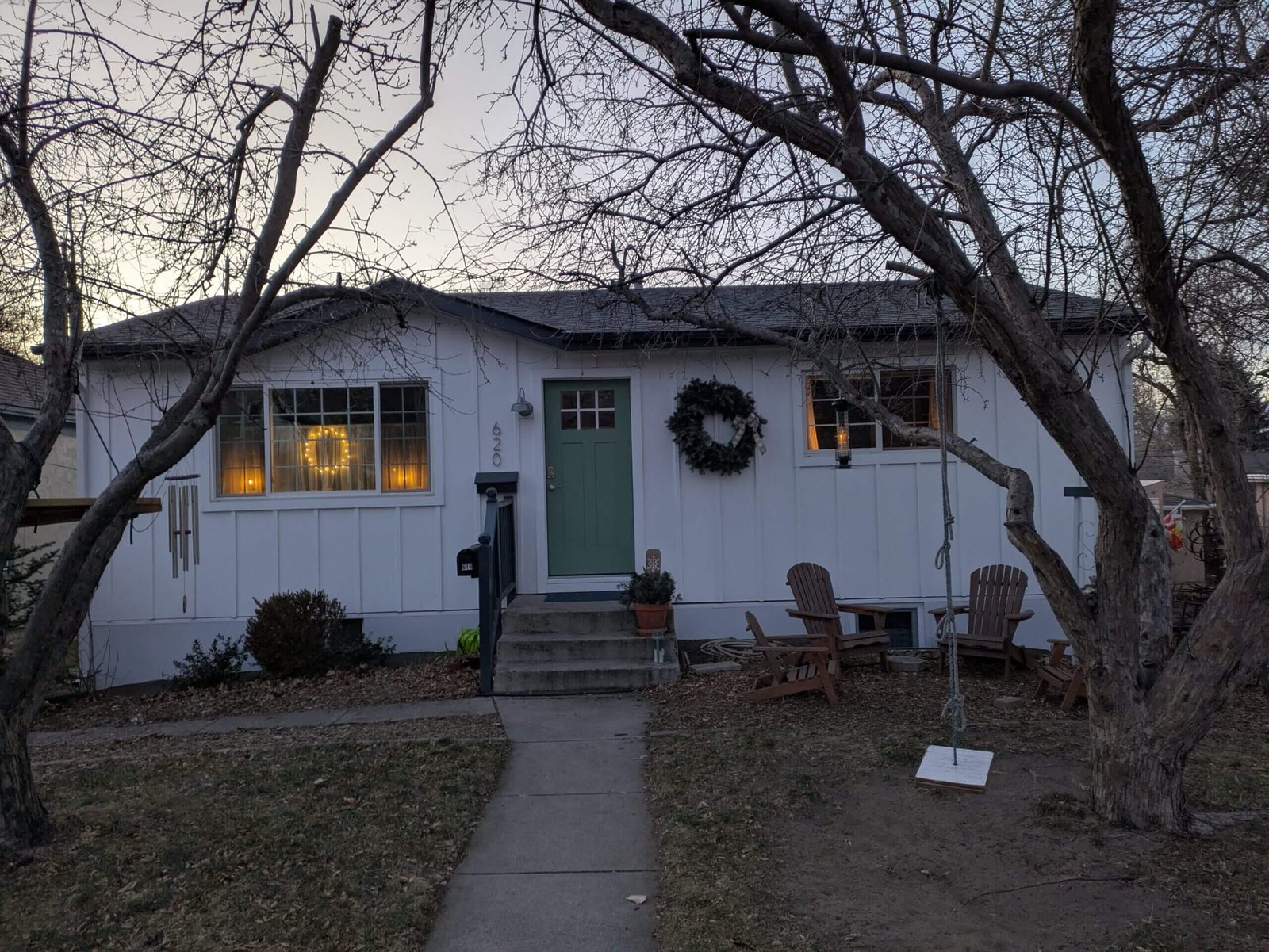 Front of McKinley house in Colorado Springs (white board and batten ranch with trees and Adirondak chairs) - in winter