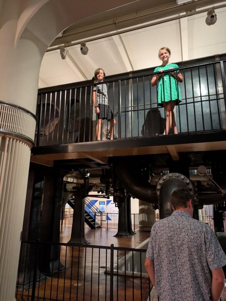 Kids standing in front of large power generator