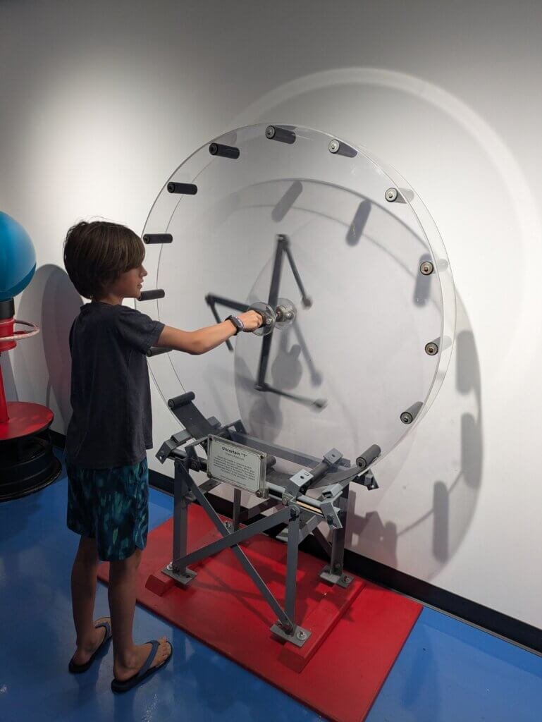 Boy playing with metal and glass contraption
