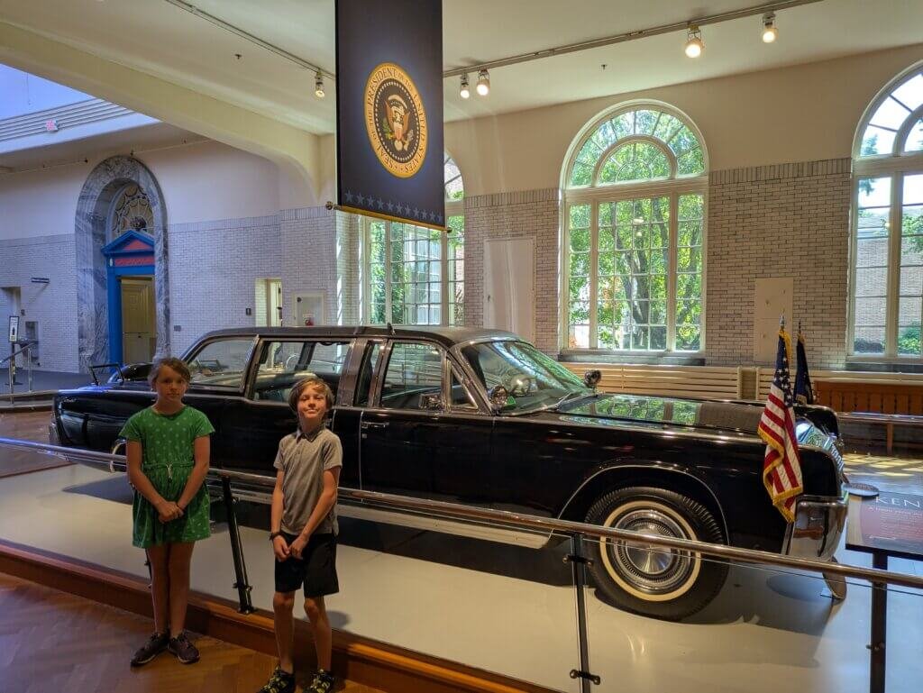 2 kids in front of limousine