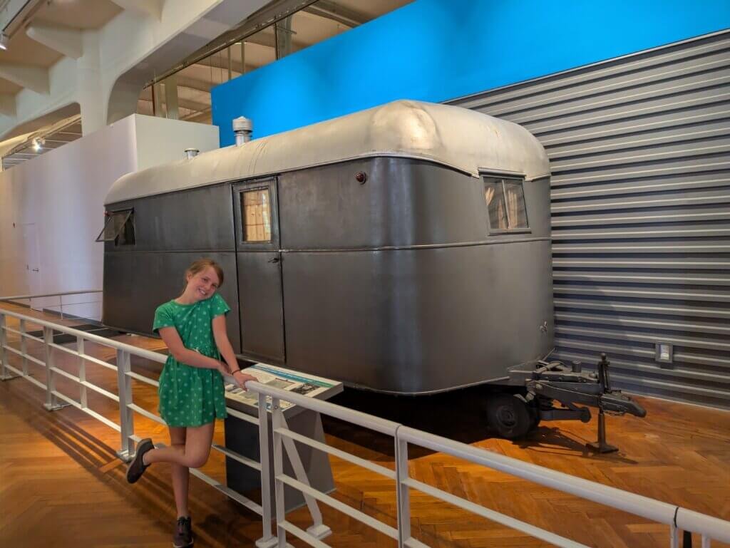 Girl in front of old travel trailer