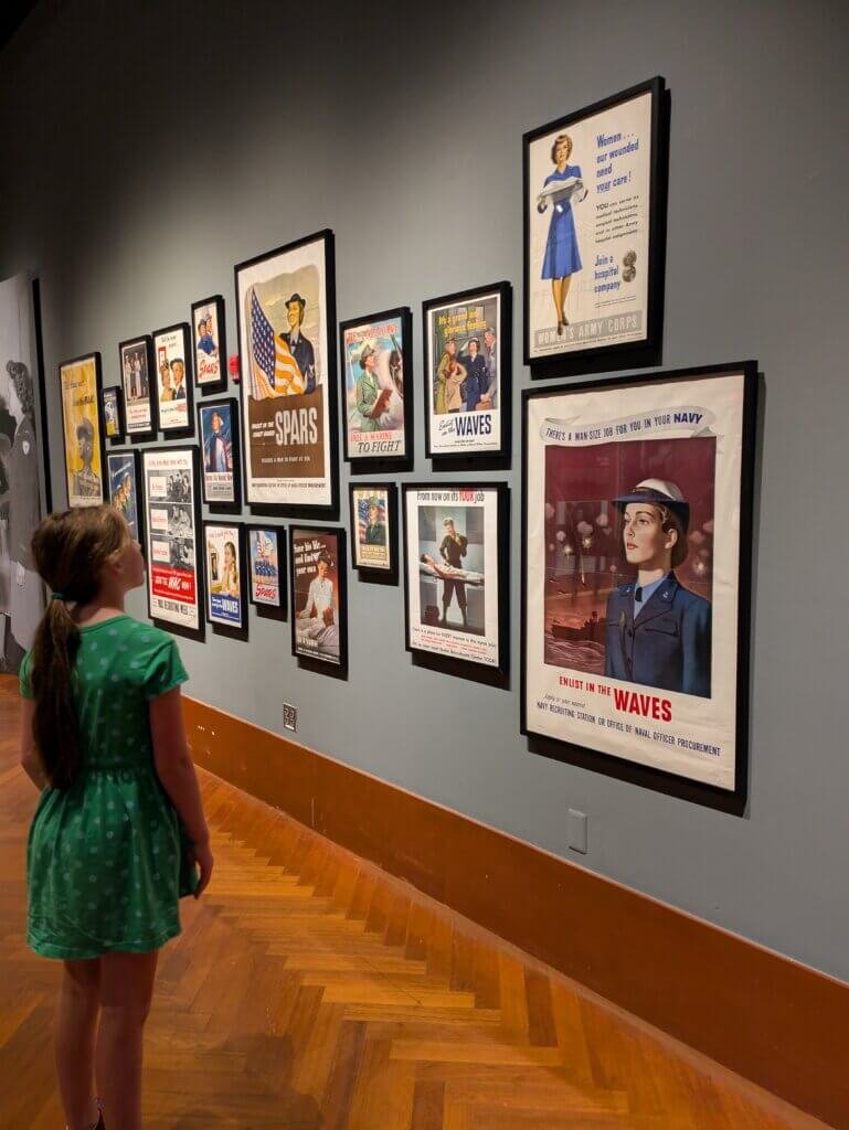 Claire standing in front of a wall of pictures
