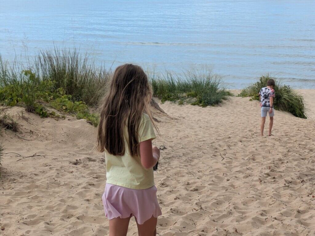 kids arriving at beachy shore with dune grass