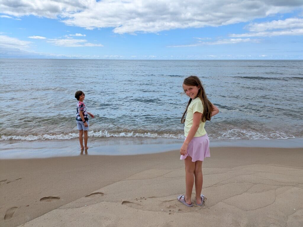 kids standing at beach shore