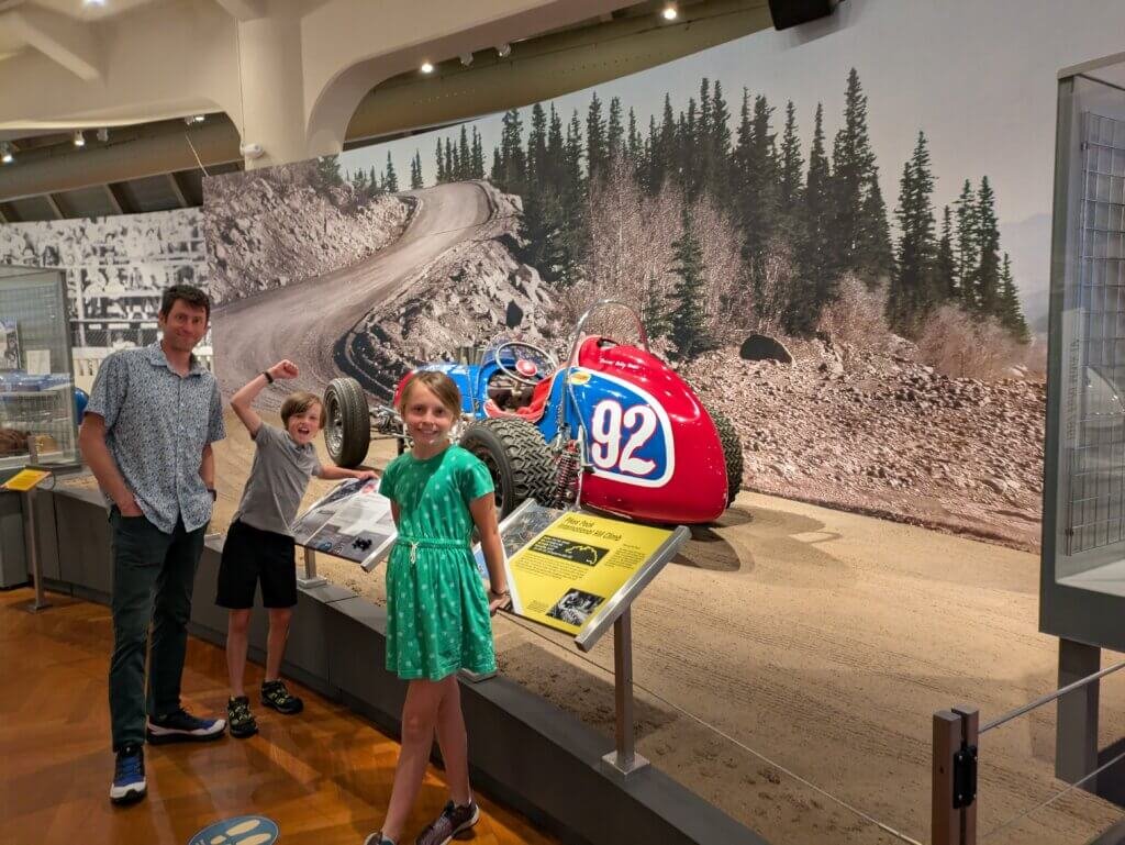 3 people standing in front of racecar