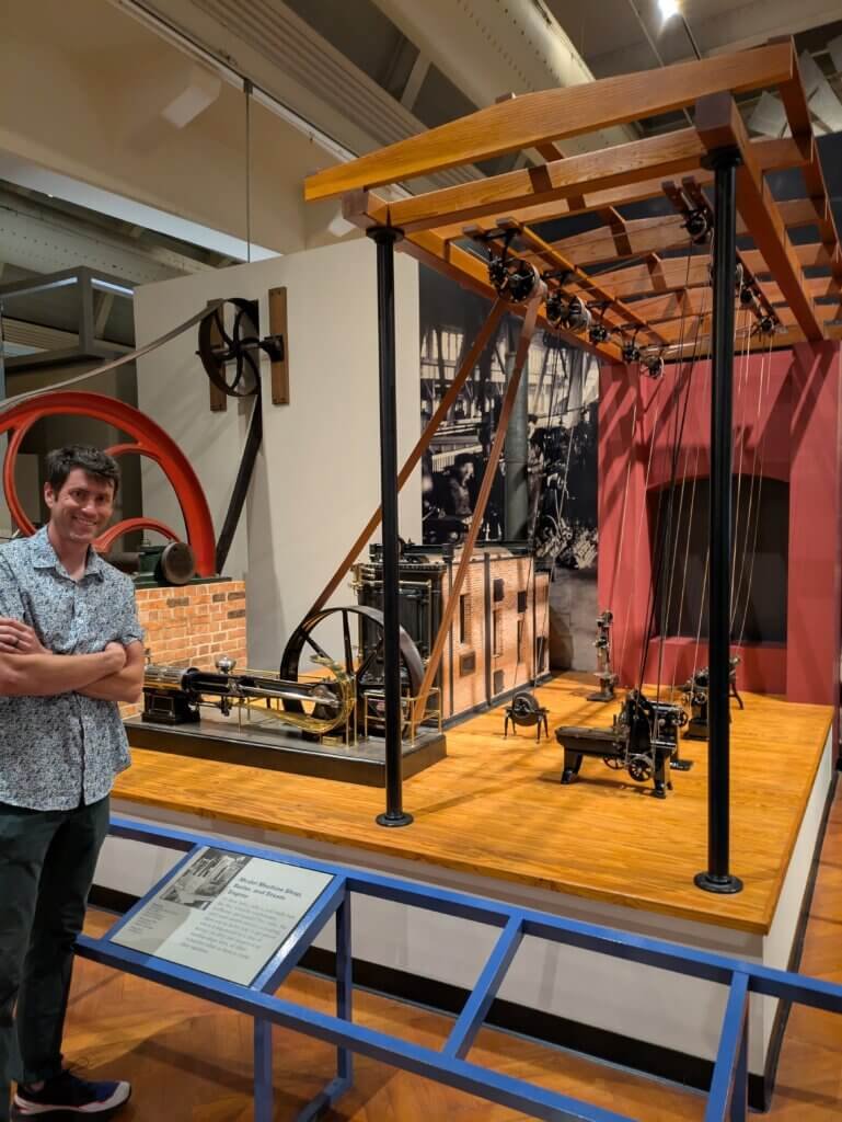 Man in front of old steam engine display