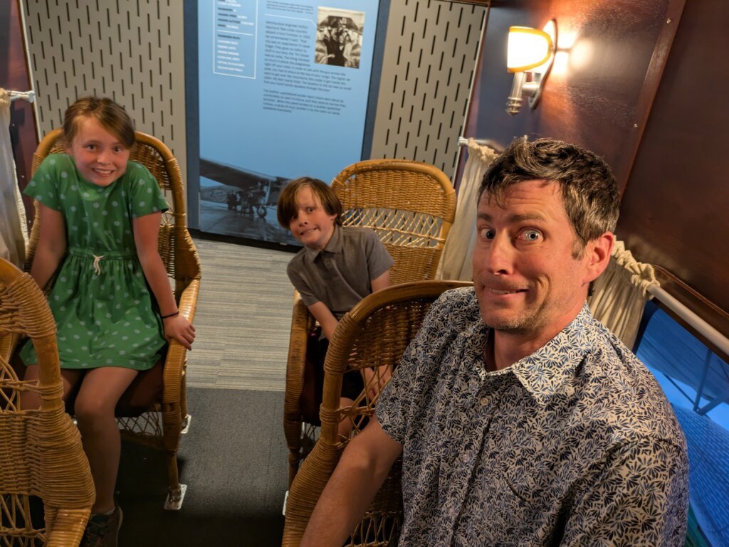 People looking nervous in plane display with wicker seats